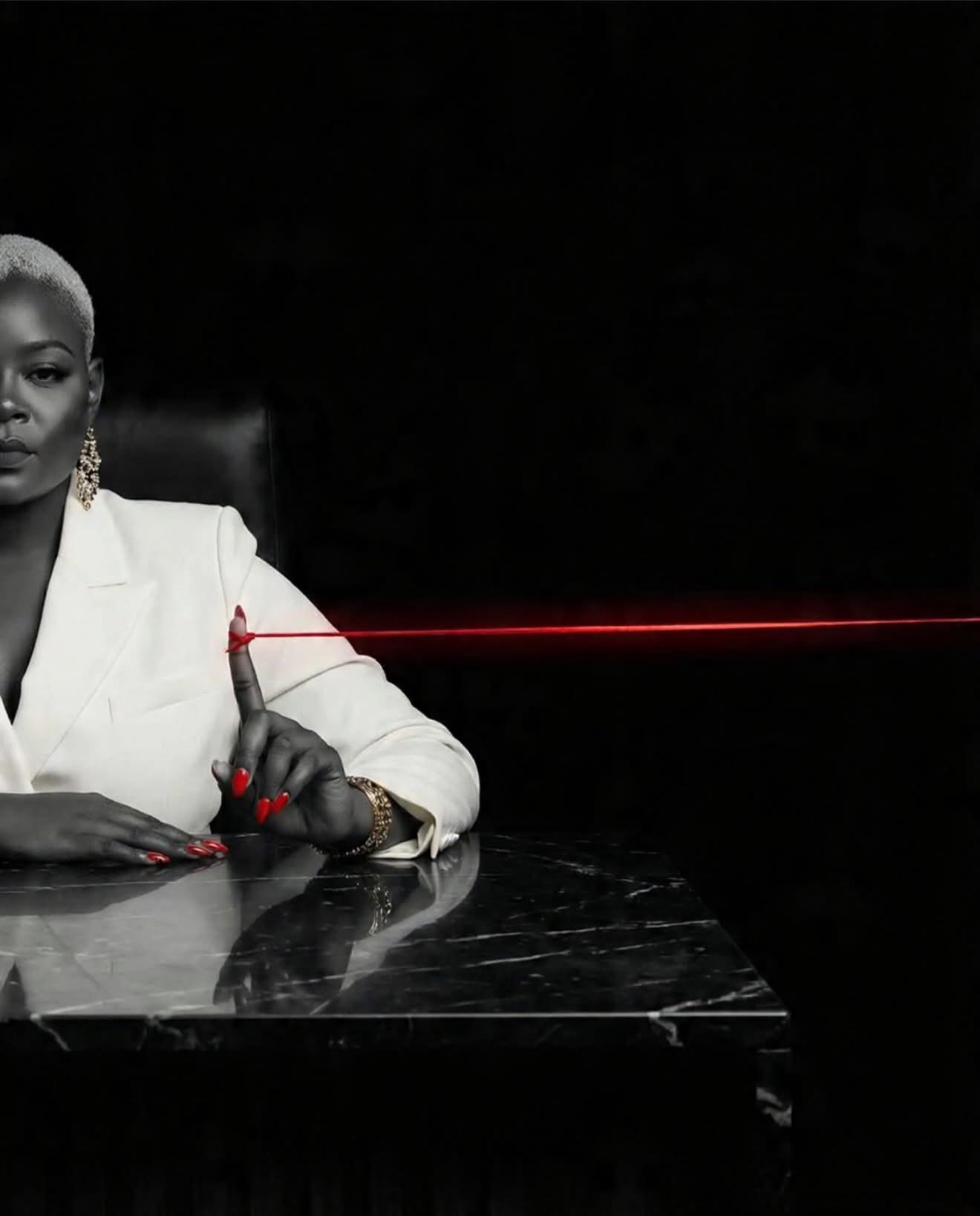 D.Chanel in white, drawing a single red line across a black marble table